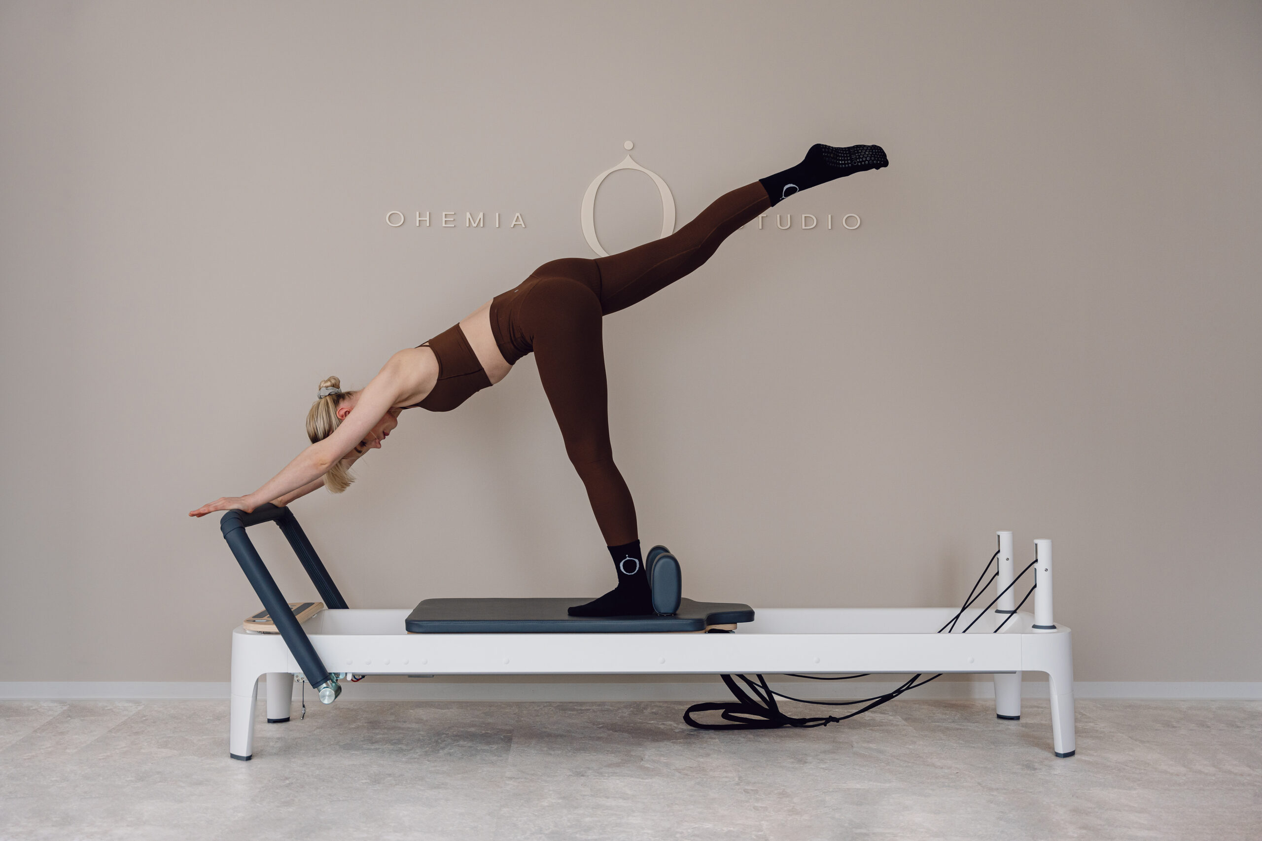 Valerie demonstriert eine Übung aus dem Kurs Reformer x HIIT im OHEMIA Studio Stuttgart