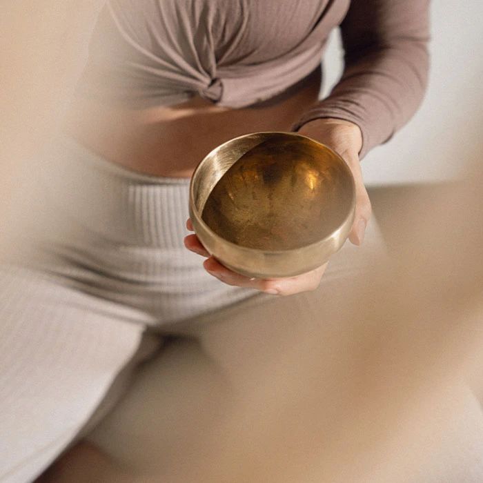 Sitzende Frau mit Klangschale im OHEMIA Studio Stuttgart bei einem Yoga oder Pilates Event